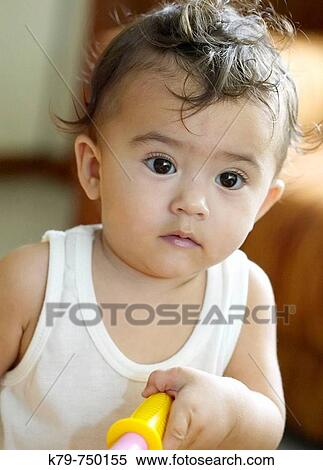 Asian/American (Philippine/American) one year old girl at home holding handle to tricycle View Large Photo Image Stock Photography - Asian/American (Philippine/American) one year old girl at home holding handle to tricycle. Fotosearch
