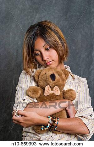Asian/Spanish teen girl cuddling a stuffed animal. View Large Photo Image Stock Image - Asian/Spanish teen girl cuddling a stuffed animal.. Fotosearch