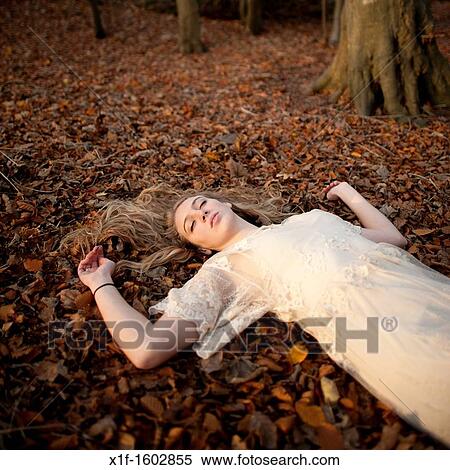 asleep on the ground - a slim blonde woman girl alone in woodland autumn afternoon daytime UK View Large Photo Image Stock Photography - asleep on the ground - a slim blonde woman girl alone in woodland autumn afternoon daytime UK. Fotosearch