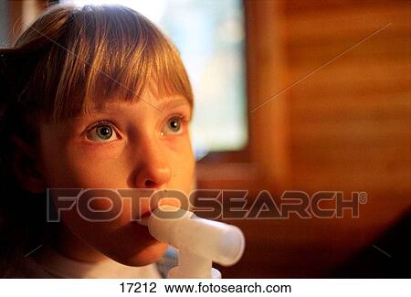Stock Image - Asthmatic girl using inhaler. Fotosearch