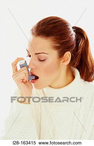 Stock Photography - Asthmatic woman using inhaler. Fotosearch