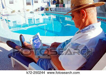 Picture - at pool with laptop. Fotosearch