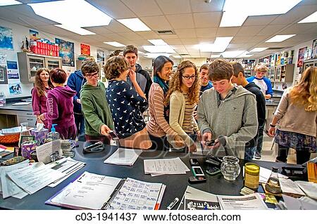 At the direction of their teacher (left background) high school chemistry students place their cell phones on her desk before class in San Clemente, CA, in an example of classroom management. View Large Photo Image Stock Photo - At the direction of their teacher (left background) high school chemistry students place their cell phones on her desk before class in San Clemente, CA, in an example of classroom management.. Fotosearch
