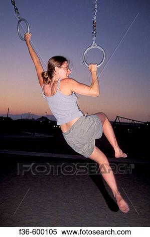 Athletic woman excersises by swinging on rings in evening at Santa Monica Beach, Santa Monica, California View Large Photo Image Stock Photography - Athletic woman excersises by swinging on rings in evening at Santa Monica Beach, Santa Monica, California. Fotosearch