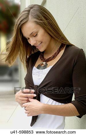 Stock Image - attractive 26 year old female leaning on wall. Fotosearch