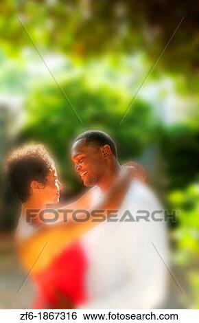 Attractive and romantic African American black couple snuggling in sunshine outdoors all dressed up beautifully View Large Photo Image Stock Photograph - Attractive and romantic African American black couple snuggling in sunshine outdoors all dressed up beautifully. Fotosearch