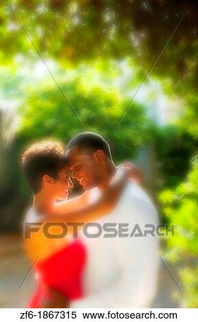 Attractive and romantic African American black couple snuggling in sunshine outdoors all dressed up beautifully View Large Photo Image Stock Photography - Attractive and romantic African American black couple snuggling in sunshine outdoors all dressed up beautifully. Fotosearch
