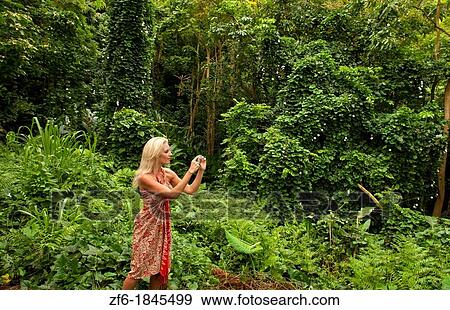 Attractive blonde woman tourist taking picture near Halona Blow Hole in East Oahu near Honolulu Hawaii View Large Photo Image Stock Photo - Attractive blonde woman tourist taking picture near Halona Blow Hole in East Oahu near Honolulu Hawaii. Fotosearch