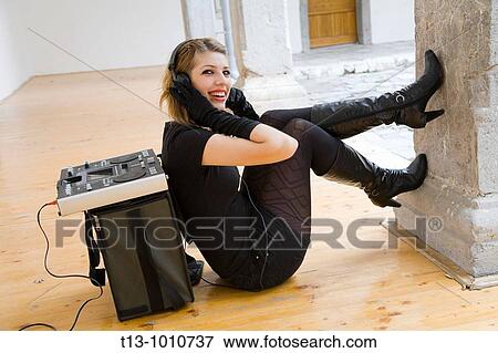 Attractive DJ young woman happy on the floor View Large Photo Image Stock Photo - Attractive DJ young woman happy on the floor. Fotosearch