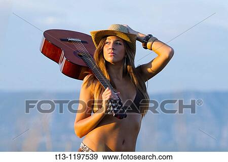 Attractive girl in bikini is carrying a guitar View Large Photo Image Stock Photo - Attractive girl in bikini is carrying a guitar. Fotosearch