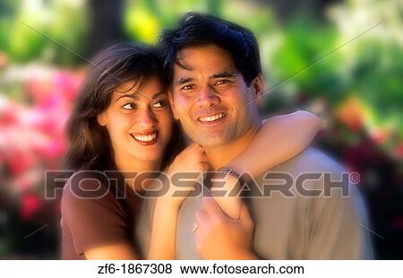 Attractive Hispanic couple outdoors with colorful background hugging and in love View Large Photo Image Stock Photo - Attractive Hispanic couple outdoors with colorful background hugging and in love. Fotosearch