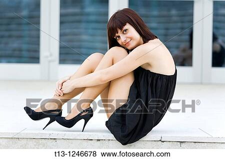 Attractive lady is tucking her shapely legs View Large Photo Image Stock Photo - Attractive lady is tucking her shapely legs. Fotosearch