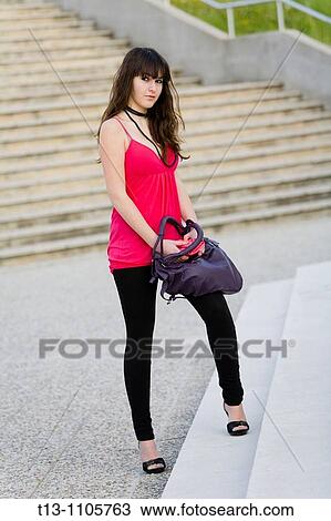Stock Image - Attractive teenager girl with a purse and a wallet. Fotosearch