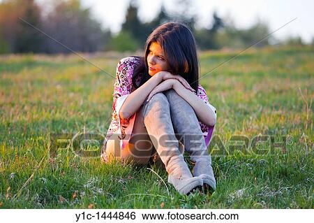 Attractive woman on the grass watching sunset View Large Photo Image Stock Photograph - Attractive woman on the grass watching sunset. Fotosearch