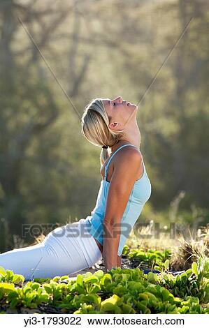 Stock Image - Attractive woman practices yoga at Makena, Maui, Hawaii. Fotosearch