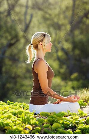Stock Photograph - Attractive woman practices yoga at Makena, Maui, Hawaii. Fotosearch