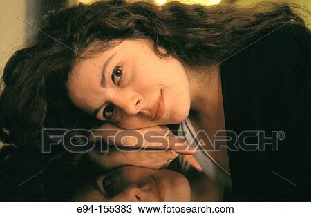 Attractive woman with long black hair resting her head on her hand on a shiny table, eyes looking at camera View Large Photo Image Stock Image - Attractive woman with long black hair resting her head on her hand on a shiny table, eyes looking at camera. Fotosearch