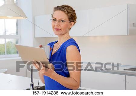 Stock Photograph - Attractive young businesswoman preparing to go to work. Fotosearch