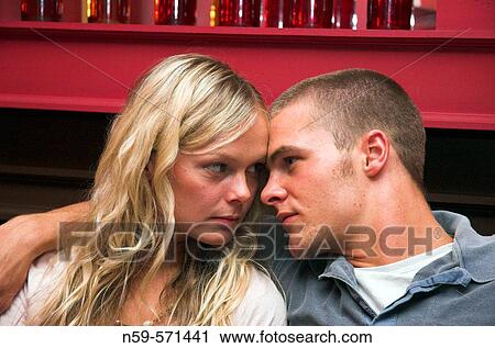 Attractive young couple cuddle up close in a bar. View Large Photo Image Stock Image - Attractive young couple cuddle up close in a bar.. Fotosearch