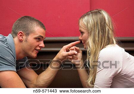 Attractive young couple flirting across a table in a bar. View Large Photo Image Stock Image - Attractive young couple flirting across a table in a bar.. Fotosearch