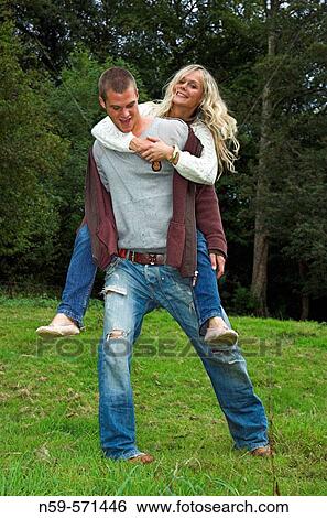 Attractive young couple playing together outdoors. View Large Photo Image Stock Photograph - Attractive young couple playing together outdoors.. Fotosearch