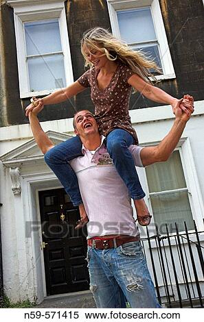 Attractive young couple playing together with the man carrying the woman in city street. View Large Photo Image Stock Photography - Attractive young couple playing together with the man carrying the woman in city street.. Fotosearch