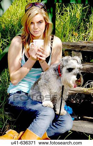 Attractive young female relaxing on the steps with a cup of coffee with her dog View Large Photo Image Stock Image - Attractive young female relaxing on the steps with a cup of coffee with her dog. Fotosearch