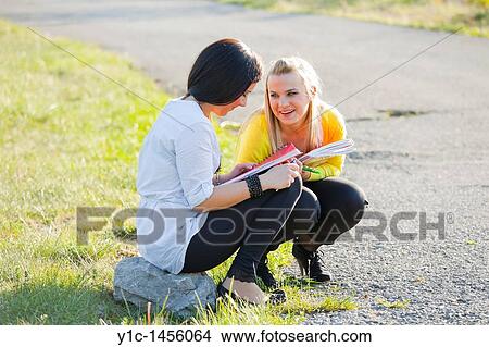 Attractive young female students waiting together by the country-road View Large Photo Image Picture - Attractive young female students waiting together by the country-road. Fotosearch