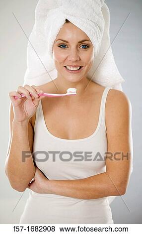 Stock Photo - Attractive young woman brushing her teeth. Fotosearch