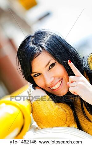 Stock Photograph - Attractive young woman cheerful happy portrait with a finger. Fotosearch