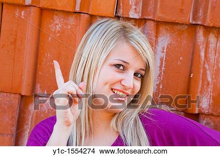 Picture - Attractive young woman happy and smiling, threat with a finger. Fotosearch