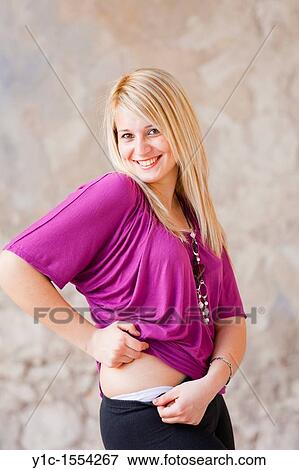 Stock Photo - Attractive young woman happy and smiling showing her knickers. Fotosearch