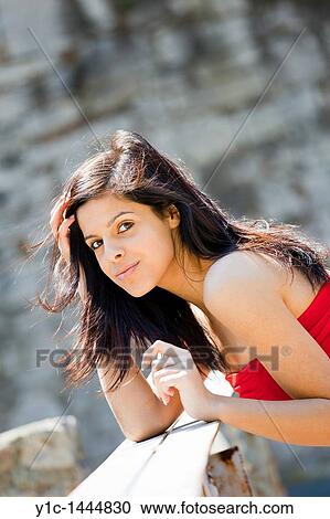 Attractive young woman in a Red dress is holding hair on a windy day View Large Photo Image Stock Image - Attractive young woman in a Red dress is holding hair on a windy day. Fotosearch