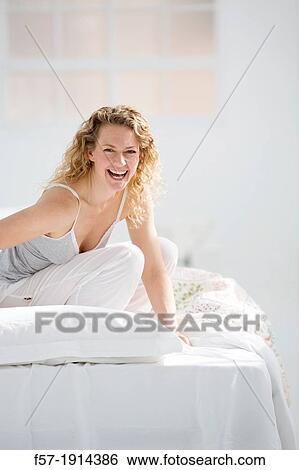 Stock Photograph - Attractive young woman in bed. Fotosearch