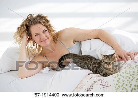 Attractive young woman in bed with her cat View Large Photo Image Stock Image - Attractive young woman in bed with her cat. Fotosearch