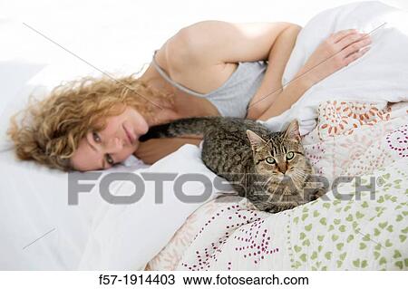 Attractive young woman in bed with her cat View Large Photo Image Stock Image - Attractive young woman in bed with her cat. Fotosearch