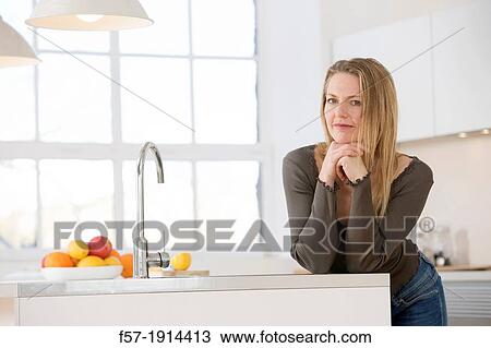 Attractive young woman in her kitchen View Large Photo Image Stock Image - Attractive young woman in her kitchen. Fotosearch