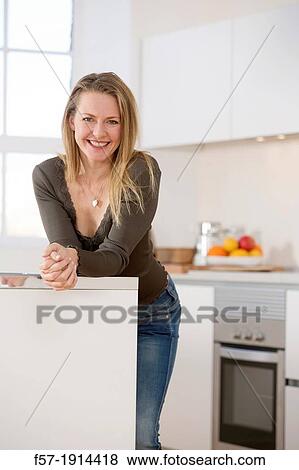 Attractive young woman in her kitchen View Large Photo Image Stock Photo - Attractive young woman in her kitchen. Fotosearch