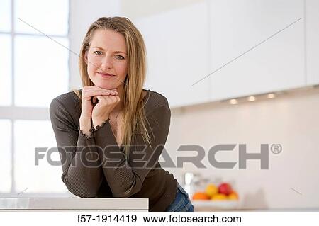 Attractive young woman in her kitchen View Large Photo Image Stock Photo - Attractive young woman in her kitchen. Fotosearch