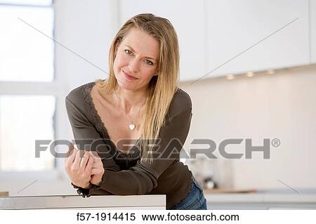 Stock Photography - Attractive young woman in her kitchen. Fotosearch
