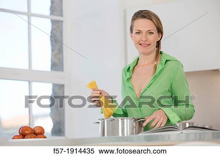 Attractive young woman in her kitchen cooking spaghetti View Large Photo Image Stock Photography - Attractive young woman in her kitchen cooking spaghetti. Fotosearch