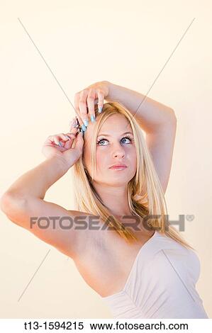 Attractive young woman is adjusting hair View Large Photo Image Stock Photography - Attractive young woman is adjusting hair. Fotosearch