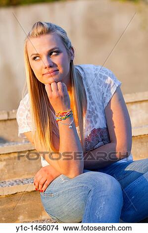 Picture - Attractive young woman is enjoying sunset light. Fotosearch
