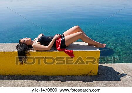 Stock Image - Attractive young woman is enjoying sun before the Summer. Fotosearch