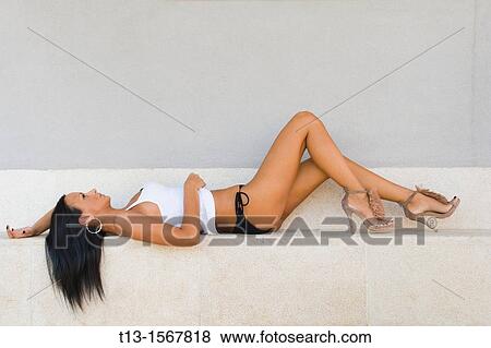 Attractive young woman is lying down on a step View Large Photo Image Stock Photo - Attractive young woman is lying down on a step. Fotosearch