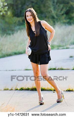 Attractive young woman is posing in short Black dress View Large Photo Image Stock Image - Attractive young woman is posing in short Black dress. Fotosearch