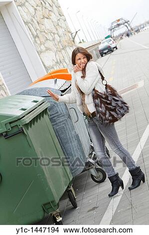 Attractive young woman is smelling garbage View Large Photo Image Picture - Attractive young woman is smelling garbage. Fotosearch
