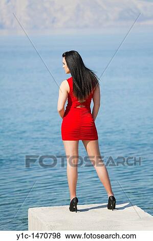 Stock Photo - Attractive young woman is standing on the edge. Fotosearch