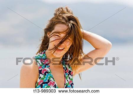 Attractive young woman is surprised by a strong blowing wind View Large Photo Image Stock Image - Attractive young woman is surprised by a strong blowing wind. Fotosearch