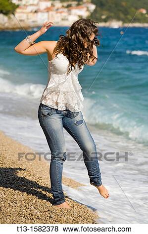 Attractive young woman is testing water with a bare foot View Large Photo Image Stock Photo - Attractive young woman is testing water with a bare foot. Fotosearch